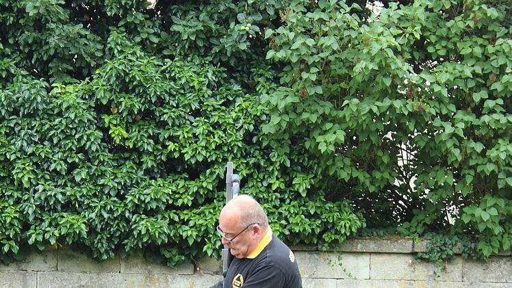Torsten Köster drückt mit exakt 500 Newton gegen einen Grabstein.
