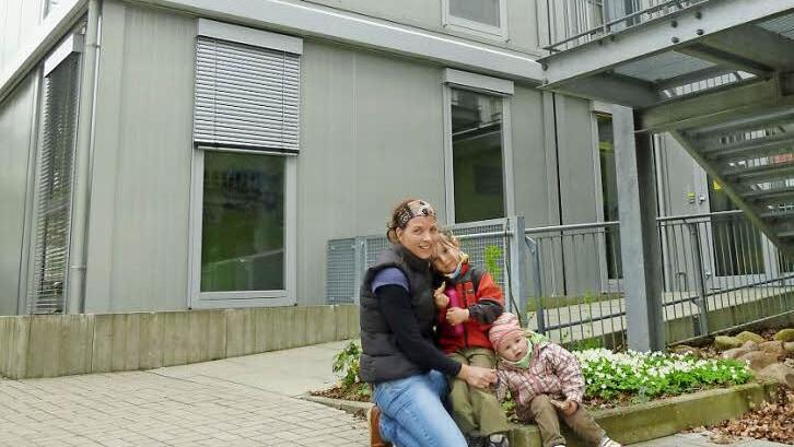 Tanja Fuhrmann holt ihre beiden Töchter Greta (4) und Ida (2) aus der Kindertagesstätte "Vogelhaus" ab. Sie werden im kommenden Jahr nach Haundorf ausweichen. Die Mutter würde sich wünschen, dass im Neubau neben Krippenkindern auch eine Kindergartengruppe eingerichtet wird. Die Container (im Hintergrund) werden verschwinden. Foto: Bernhard Panzer