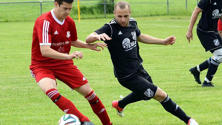 Hemhofens Alin Lazar (rechts) traf kurz vor dem Pausenpiff zum 1:1, lief hier aber gegen Tobias Schuffert ins Leere, der kurz vor Schluss für eine Notbremse die Rote Karte sah. Foto: herzopress