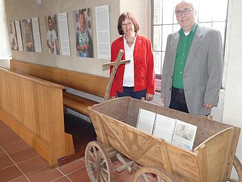 Pfarrerin Doris Schirmer-Henzler und Pfarrer Christof Henzler freuen sich über den geschichtsträchtigen Handwagen aus dem Bauernmuseum Frensdorf, der die Ausstellung bereichert.  Foto: Marion Krüger-Hundrup
