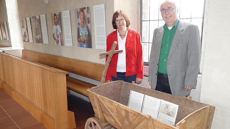 Pfarrerin Doris Schirmer-Henzler und Pfarrer Christof Henzler freuen sich über den geschichtsträchtigen Handwagen aus dem Bauernmuseum Frensdorf, der die Ausstellung bereichert.  Foto: Marion Krüger-Hundrup