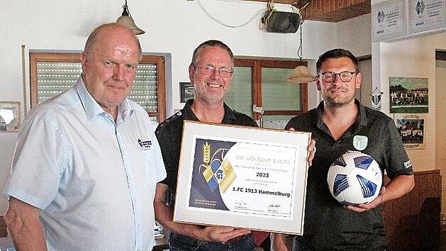 Kreisvorsitzender Rainer Lochm&uuml;ller (von links) &uuml;berbrachte zum 110. Gr&uuml;ndungsfest des FC Hammelburg die &bdquo;Goldenen Raute mit &Auml;hre&ldquo;, die FC-Ehrenamtsbeauftragter Martin Stapper und Vorsitzender Christian Ohmert entgegennahmen.