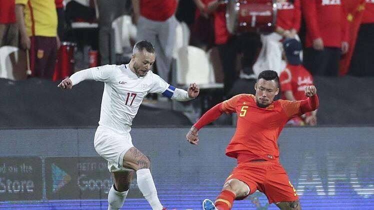 Der aus Schweinfurt stammende Deutsch-Filipino Stephan Schröck wird im Gruppenspiel gegen China von Zhang Linpeng attackiert. Beim 0:3 hatten die "Azkals" keine Chance.imago