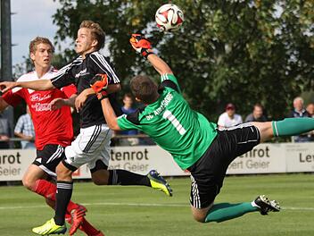 Der Adelsdorfer Keeper Lukas Heinsch klärt vor dem Röttenbacher Stürmer im ersten Saisonspiel. Der SC setzte sich am Ende mit 3:0 durch.  Foto: Uwe Kellner
