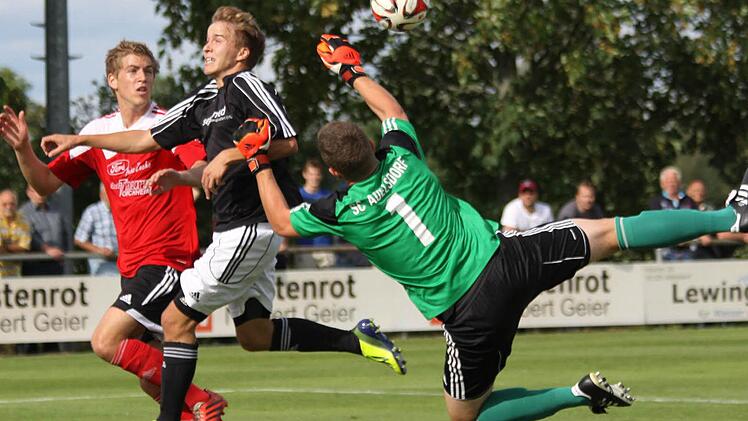Der Adelsdorfer Keeper Lukas Heinsch klärt vor dem Röttenbacher Stürmer im ersten Saisonspiel. Der SC setzte sich am Ende mit 3:0 durch.  Foto: Uwe Kellner