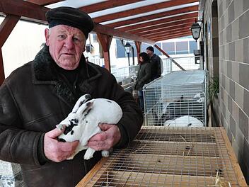 Beim ersten Taubenmarkt in diesem Jahr am Gasthaus Faber-Rädlein in Ibind war Willy Müller aus Lahm als Züchter dabei. Auf dem Arm hält er stolz einen Hasen der Rasse "Dalmatiner Rex". Foto: Simon Albrecht