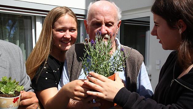 Lea-Marie Dorsch (links) und Sonja Herold lassen Heimbewohner Kurt Kuch am duftenden Lavendel schnuppern. Dagmar Besand