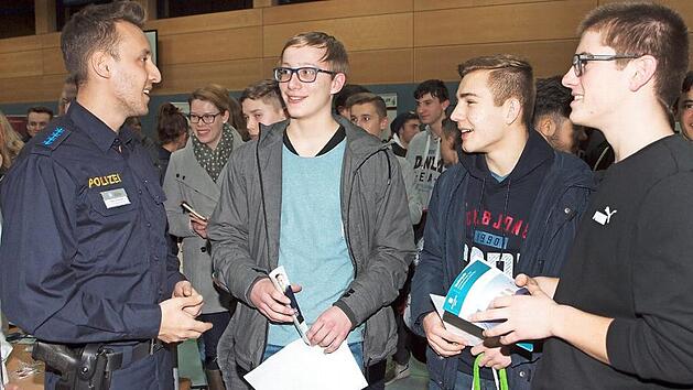 Drei Sch&uuml;ler der 11. Klasse des Meranier-Gymnasiums lie&szlig;en sich von Erdem Demirezen (links) von der Einstellungsberatung der Polizei Coburg &uuml;ber die beruflichen M&ouml;glichkeiten bei der Polizei aufkl&auml;ren. Fotos: Alfred Thieret