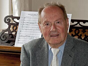 Der in Ahorn lebende Komponist Gerhard Deutschmann wird am Samstag 80 Jahre alt. Im Hintergrund: Die Partitur seines Doppelkonzerts für Violine, Violoncello und Streichorchester, das noch der Uraufführung harrt. Foto: Jochen Berger