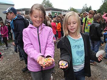 Paula Rebiger und Sophie Beland freuen sich, dass sie vom Bonbonregen, den Zimmermann Gerhard Kögel auf die Kinder niederprasseln ließ, so viele Süßigkeiten abbekommen haben. Fotos: Sonja Adam