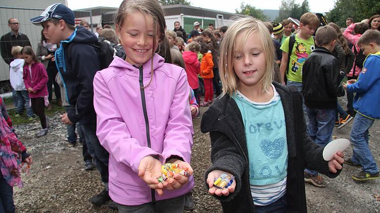 Paula Rebiger und Sophie Beland freuen sich, dass sie vom Bonbonregen, den Zimmermann Gerhard Kögel auf die Kinder niederprasseln ließ, so viele Süßigkeiten abbekommen haben. Fotos: Sonja Adam