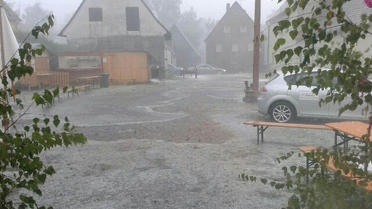 Vor dem Kirchweih-Festzelt des Burschenvereins Dormitz strömen Regen- und Hagelmassen Richtung Hauptstraße. Foto: Markus Welte