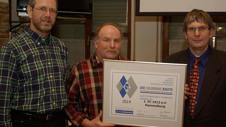 Kreisehrenamtsbeauftragter Klaus Eisenmann überbrachte zum zweiten Male das Gütesiegel des BFV, die silberne Raute, die Andreas Ruppert und Martin Stapper (v. r.) für den FC Hammelburg entgegennahmen. Foto: heg