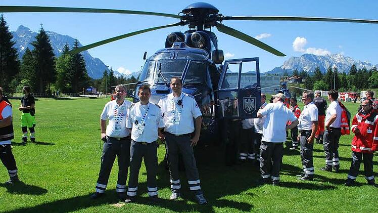 Michael Stelzner (Coburg), Ralf Schmidt (Kronach) und Maximilian Türk (Kulmbach, von links) teilten sich die Führungsaufgaben für das BRK-Kontingent. Hier stehen sie vor Angela Merkels Hubschrauber.