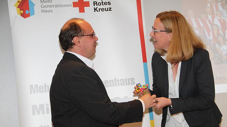 Dekanin Stefanie Ott-Frühwald überreicht an Einrichtungsleiter Frank Gerstner ein Kreuz.
