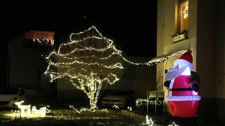 In Rattelsdorf begrüßt ein großer Weihnachtsmann Gäste und Bewohner dieses beleuchteten Anwesens in der Weiße-Kreuz-Straße. Foto: Schanz