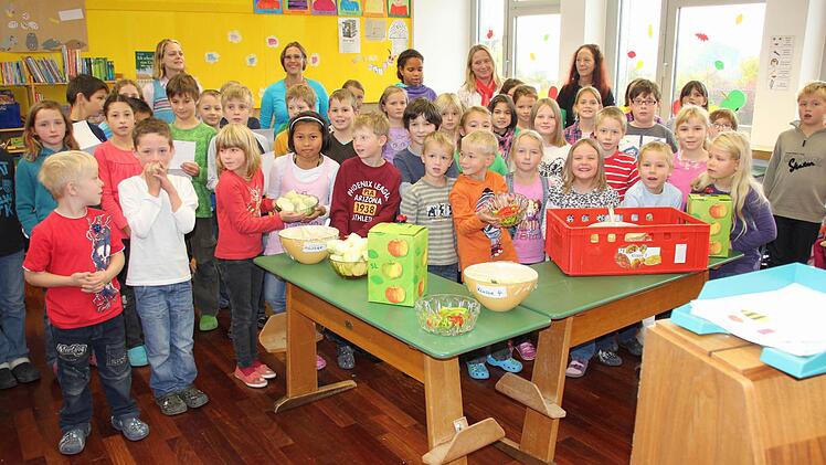 Die Untermerzbacher Grundschüler präsentieren ihr gesundes Frühstück und Jonas (vorne im weißen Hemd) beißt in einen Kohlrabi. Ganz hinten: die Lehrerinnen Sabine Pascher, Angela Weisenseel, Gerlinde Megges und Hiltrud Rössner beim Dorfladen.