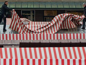 Zwei Männer montieren in Nürnberg die Dachplane an einem Verkaufsstand auf dem Christkindlesmarkt. Am 29. November wird der Markt offiziell mit dem Prolog des Nürnberger Christkinds eröffnet. Foto: Daniel Karmann/dpa