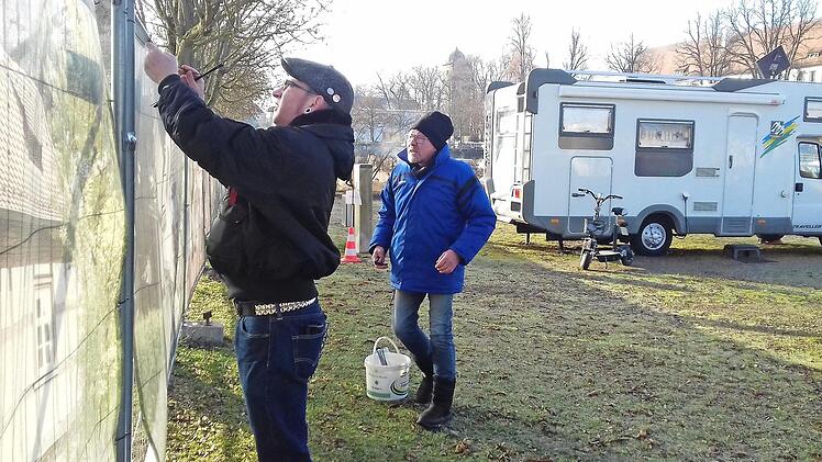 Florian Dominka (links) und Alexander Baginski beim Reparieren des Fotozauns am Wohnmobilstellplatz. "Jetzt, wo noch nicht so viele Leute da sind, haben wir noch Zeit für solche Arbeiten", sagt Baginski.