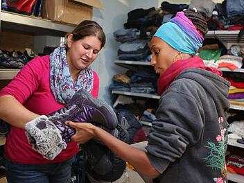 Zwei Helferinnen sortieren im Keller der Flüchtlingsunterkunft an der Forchheimer Piastenbrücke Winterschuhe für Flüchtlinge. Fotos: Barbara Herbst