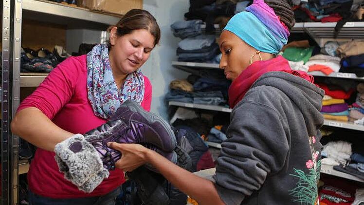 Zwei Helferinnen sortieren im Keller der Flüchtlingsunterkunft an der Forchheimer Piastenbrücke Winterschuhe für Flüchtlinge. Fotos: Barbara Herbst