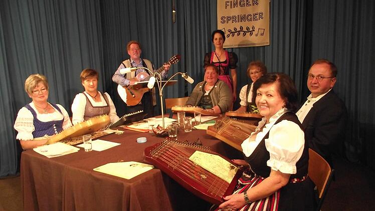 Die Akkordzithergruppe "Fingerspringer" mit (von links) Brigitte Brückner, Evi Hargens, Siggi Winkler, Christine Winkler, Moderatorin Sandra Scheffler, Renate Glaser, Veronika Petrat und Heinrich Glaser. Foto: Dieter Wolf