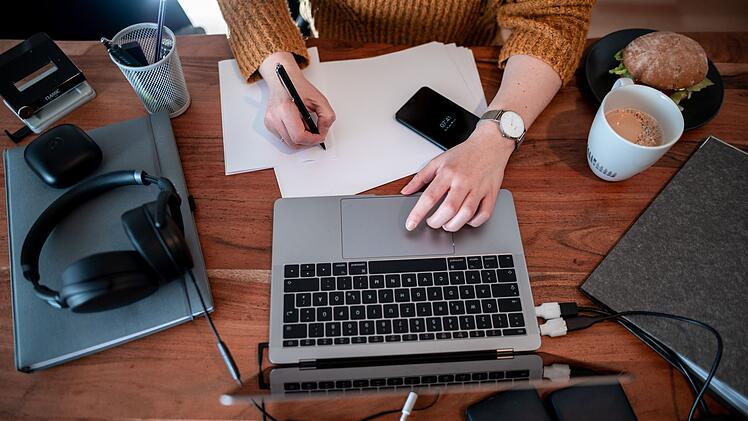 Frau arbeitet daheim an einem Laptop