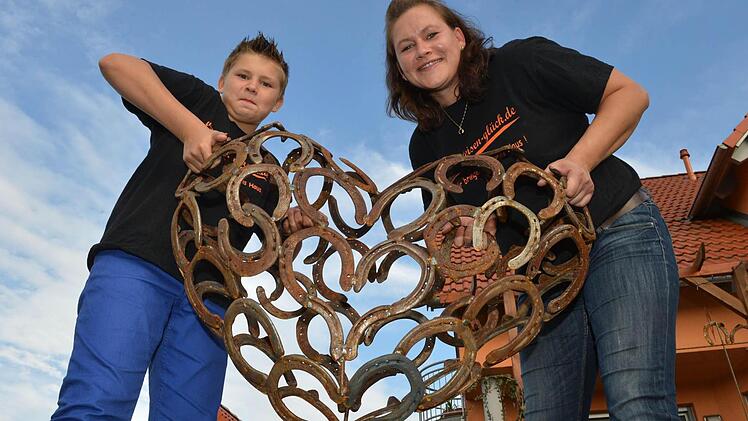 Katja Binz und Sohn Dominik mit dem dreidimensionalem Herz aus Hufeisen. Foto: Ronald Rinklef