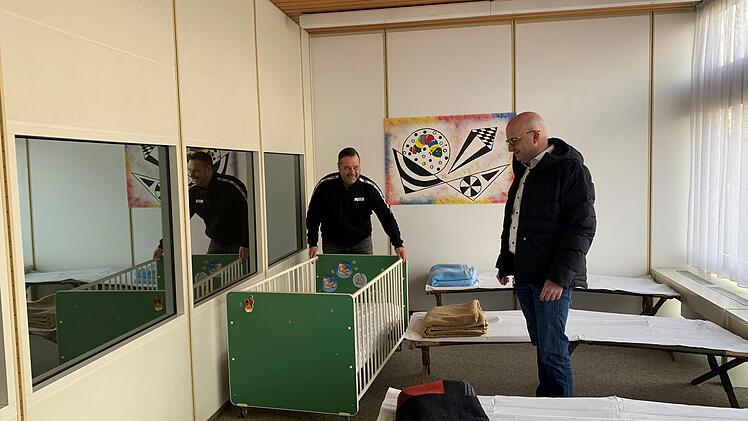 Stadt-Hausmeister Jörg Hofmann (links) und Bürgermeister Michael Kastl in einem Raum der Notunterkunft. Es stehen sogar Kinderbetten für die Flüchtlinge bereit. Foto: Thomas Malz