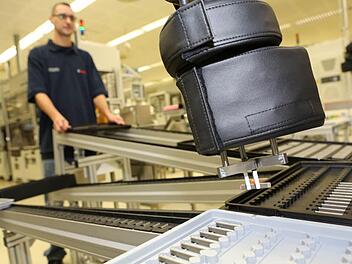 In der Bamberger Fertigung von Piezo-Aktoren - ein Produkt, das später Bestandteil eines Einspritz-Injektors wird - arbeiten inzwischen auch käfigfreie Roboter mit "Sensorhaut" Seite an Seite mit Menschen (vorne ein Greifarm eines solchen Roboters, der einen Aktor hält). Foto: Barbara Herbst