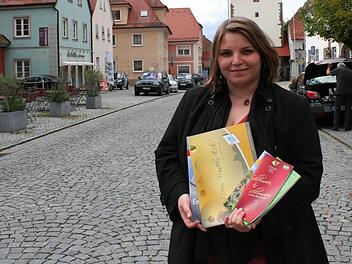 Stefanie Rauh will mit ihrem Projektmanagement die Region und den Tourismus im Drei-Franken-Eck stärken. Vor dem Schlüsselfelder Stadttor präsentiert sie Prospekte und Broschüren, die das Projektbüro aufgelegt hat. Foto: Evi Seeger
