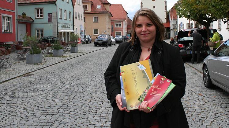 Stefanie Rauh will mit ihrem Projektmanagement die Region und den Tourismus im Drei-Franken-Eck stärken. Vor dem Schlüsselfelder Stadttor präsentiert sie Prospekte und Broschüren, die das Projektbüro aufgelegt hat. Foto: Evi Seeger