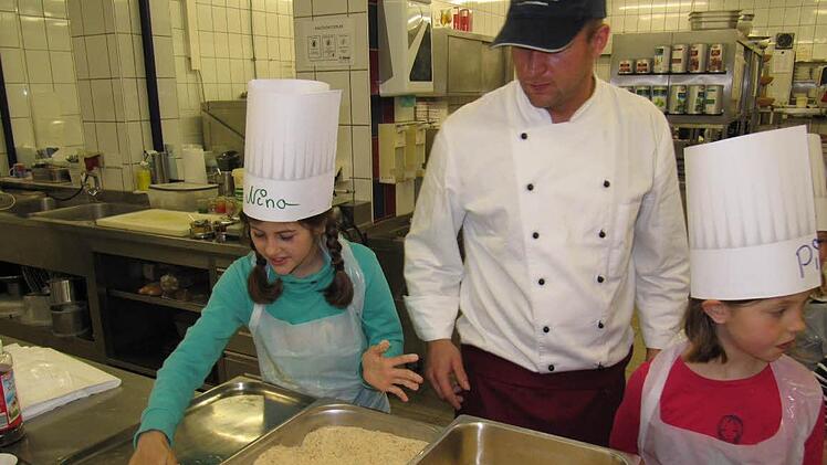 Nach dem Klopfen und Würzen wird das Fleisch zuerst in Mehl, dann in Ei und Semmelbröseln gewendet. Nina (links) kann das schon gut.