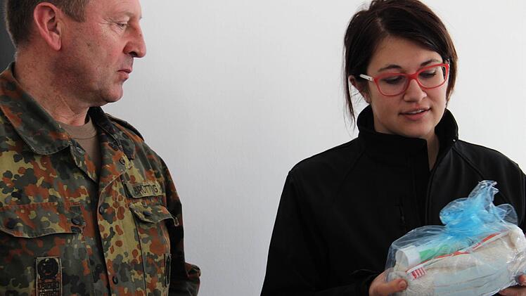 Stefan Brütting, der Leiter des Kreisverbindungskommandos Kulmbach der Bundeswehr mit Julia Brückner, die gerade die Hygienesets zeigt, die jeder Flüchtling bei der Ankunft bekommt. Fotos: Katharina Müller-Sanke