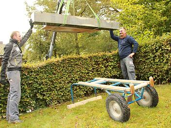 Thomas Dinkel (links) und Wolfgang Zillig von der  Staffelsteiner Steinmetzfirma Kerner setzen  einen Grabstein im Draisdorfer Friedhof, nachdem die Inschrift neu vergoldet worden ist. Foto: Matthias Einwag