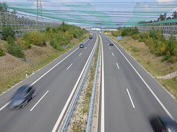 Zur Sicherheit rollt der Verkehr auf der A 73 bei Waldsachsen zurzeit unter einem Netz hindurch. Es soll verhindern, dass etwas auf die Fahrbahn fällt, wenn die Leiterseile auf die Strommasten der 380-kV-Leitung in diesem Abschnitt aufgezogen werden. Fotos: Rainer Lutz