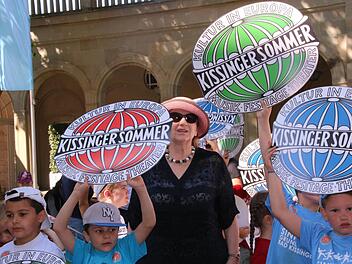 Der Kissinger Sommer hat begonnen. Zur Einstimmung zogen gestern 300 Kinder singend durch die Innenstadt. Auch Intendantin Kari Kahl-Wolfsj&auml;ger h&ouml;rte zu. Foto: Markus Klein