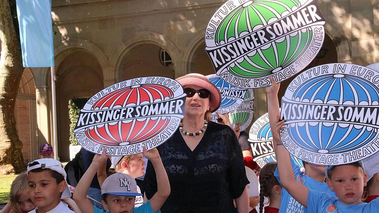 Der Kissinger Sommer hat begonnen. Zur Einstimmung zogen gestern 300 Kinder singend durch die Innenstadt. Auch Intendantin Kari Kahl-Wolfsj&auml;ger h&ouml;rte zu. Foto: Markus Klein