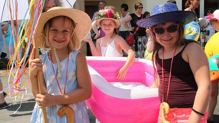 Gut behütet und mit einem Planschbecken reihten sich (von links) Katharina Frosch, Rosalie Bachmann und Eva Tröglein (alle 7) in den Melkendorfer Wiesenfest-Umzug. Foto: Stephan Stöckel
