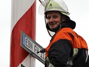 Simon Gerstenkorn befestigt das EBN-Schild in luftiger Höhe am Maibaum.  Foto: Eckehard Kiesewetter