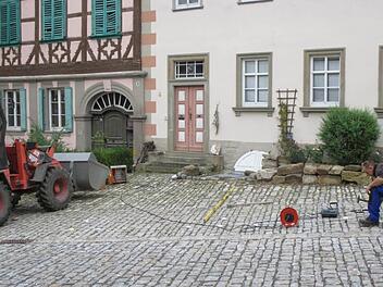 Städtische Arbeiter kennzeichnen mit Nägeln die 29 Parkboxen auf dem Marktplatz von Königsberg. Damit werden die Stellflächen eindeutig markiert.  Foto: Gerold Snater