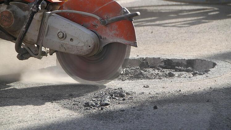 Soll es auch nicht... mit einer Flex schneiden die Bauarbeiter die Asphaltdecke wieder auf.