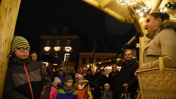 Die  Korbstadtkönigin erzählt den Kindern auf dem Weihnachtsmarkt eine Geschichte. Foto: Wiedemann