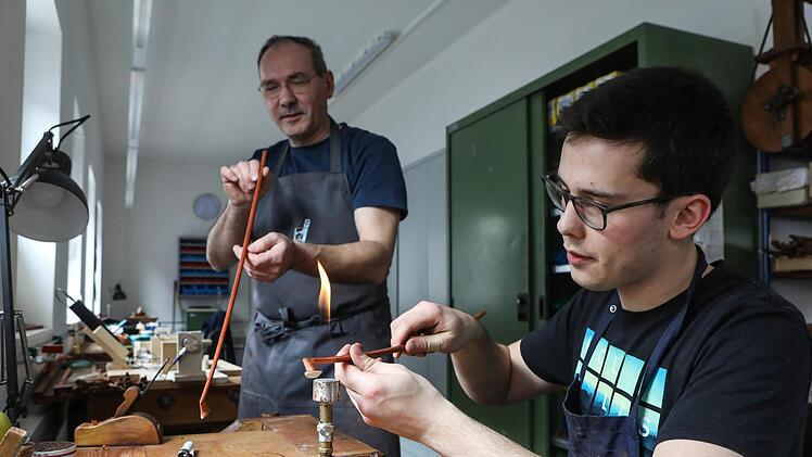 Bogenmachermeister Günther Spätling begutachtet die Arbeit des Lehrlings. Foto:  Barbara Herbst