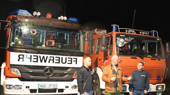 B&uuml;rgermeister Gerald Brehm (Mitte) &uuml;bergab den Schl&uuml;ssel f&uuml;r das neue Feuerwehrauto (links) an den Kommandanten der Zentbechhofener Wehr, Heiko Ganzmann. Rechts der amtierende Kommandant der Freiwilligen Feuerwehr H&ouml;chstadt, Benjamin Obexer, vor dem alten Auto.  Foto: privat