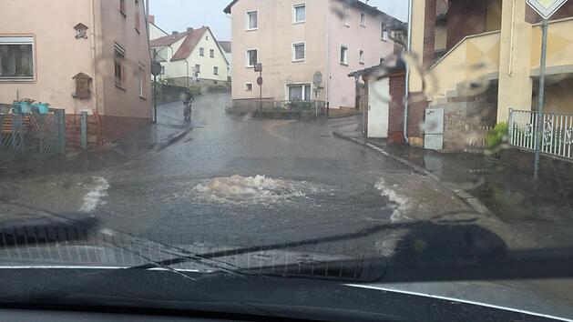 So erlebte Jacqueline Ke&szlig;ler das Unwetter am vergangenen Sonntag in Wollbach: Gleich mehrere Kanaldeckel in der Rh&ouml;nstra&szlig;e hatte es abgehoben, aus dem Kanal sprudelt das Wasser auf die Stra&szlig;en. Gleich in mehreren Stra&szlig;en standen Keller unter Wasser. Foto: Jacqueline Ke&szlig;ler