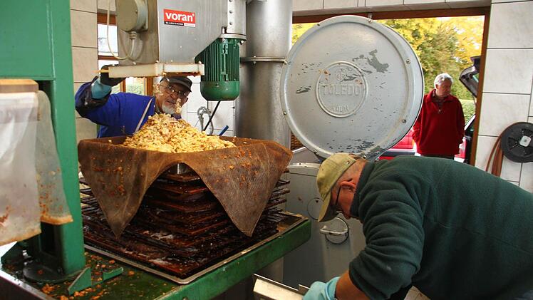 In dem Moser werden die Früchte gepresst. Die Abfälle, die die Maschine ausspuckt, werden aufgefangen. Den so genannten Trester bekommen Jäger, die damit das Wild füttern. Seit Jahren an der Presse des Obst- und Gartenbauvereins Schwarzach-Schmeilsdorf arbeiten Herbert Sommer (links) und Wilfried Högen.  Fotos: Jürgen Gärtner