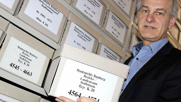 Archivoberrat Klaus Rupprecht vor den Akten des ehemaligen Bezirks- und Landratsamts Staffelstein. Insgesamt besitzt das Staatsarchiv rund 5000 Archivalien dieser Behörde. Allesamt sind sorgsam gereinigt, inventarisiert und in Karton vor Staub und Lichteinflüssen geschützt.