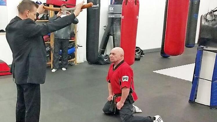 Harald R&ouml;gner bekommt ein Schwert als Symbol seiner bestandenen Pr&uuml;fung verliehen. Foto: Katrin Pauleit