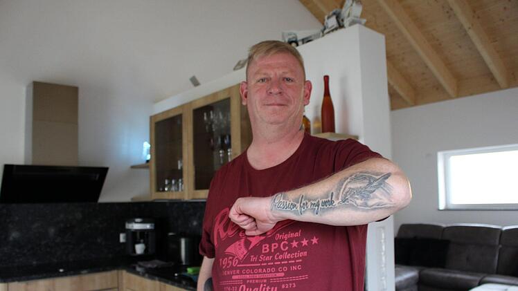 Oliver Fell wohnt mit seiner Lebensgefährtin im Ortskern von Oberleichtersbach. Seine Tattoos sind sein Markenzeichen. Foto: Julia Raab